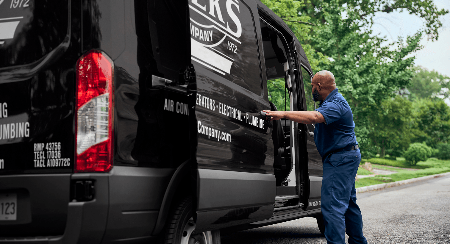 A professional Weeks technician opening a black service van on a residential street, ready to provide home HVAC, plumbing, and electrical services.