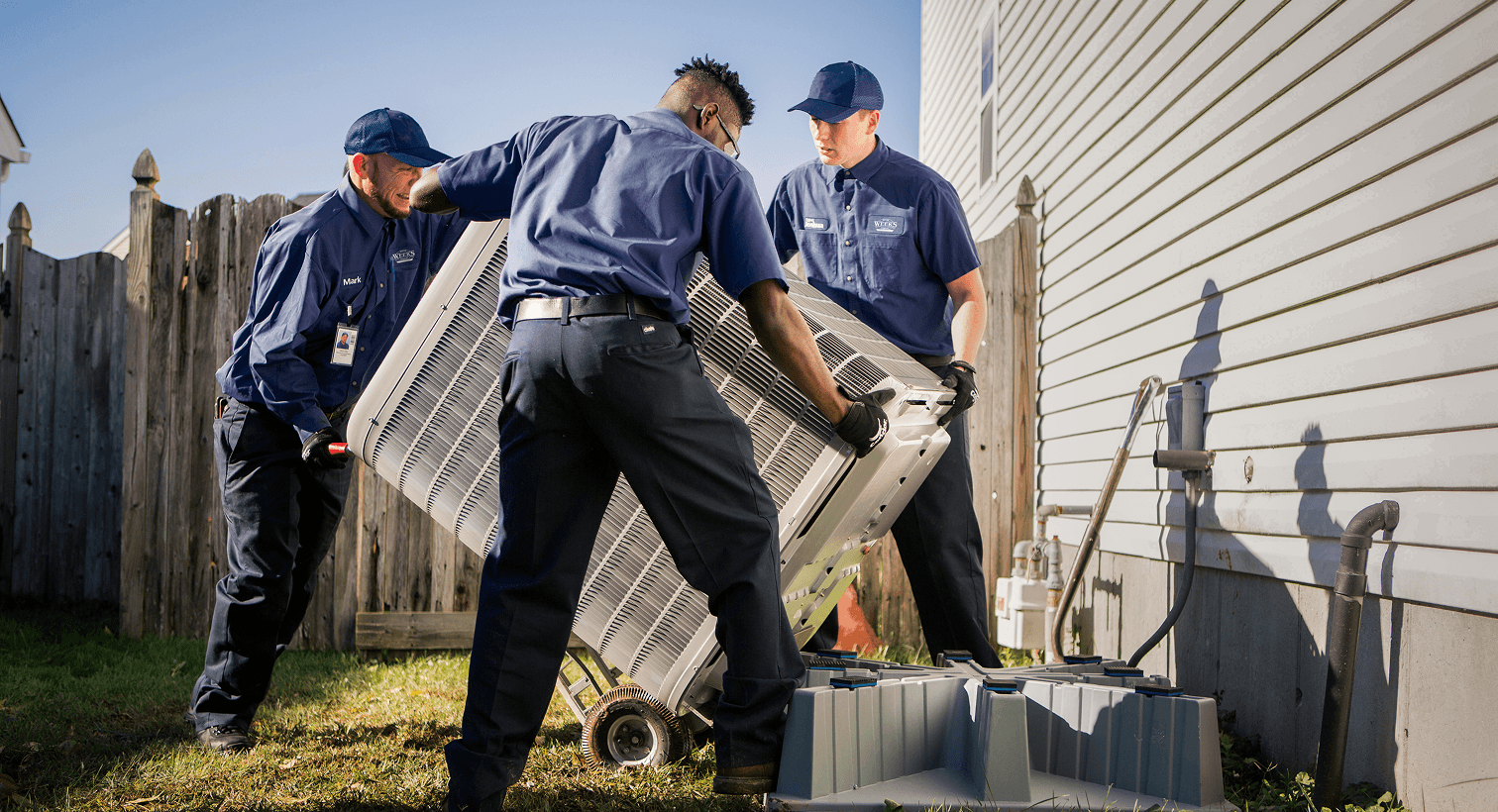 HVAC technicians installing a new residential air conditioning system.