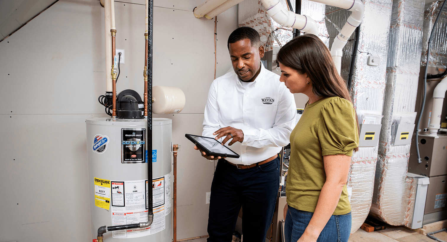 Plumbing technician discussing residential plumbing service with a homeowner.