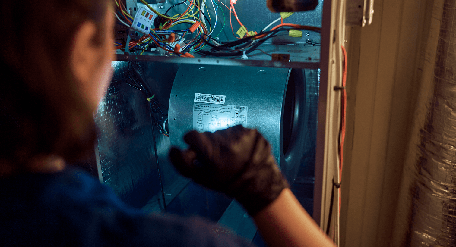 HVAC technician inspecting a residential heating system during a replacement service.